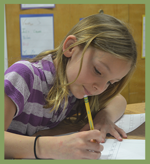 Student writes on a piece of paper with pencil