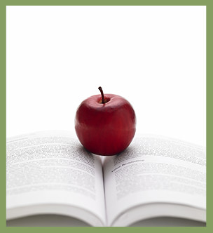 Apple sitting in the center of an open book